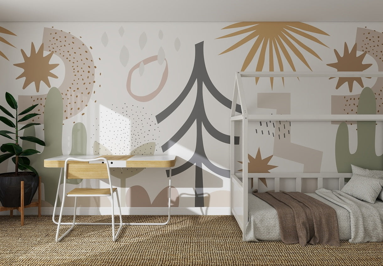 A modern kids’ room with a white bed, wooden desk and chair, potted plant, and vibrant Audrey Abstract Wallpaper Mural featuring abstract shapes, trees, and stars in beige, brown, green, and black.