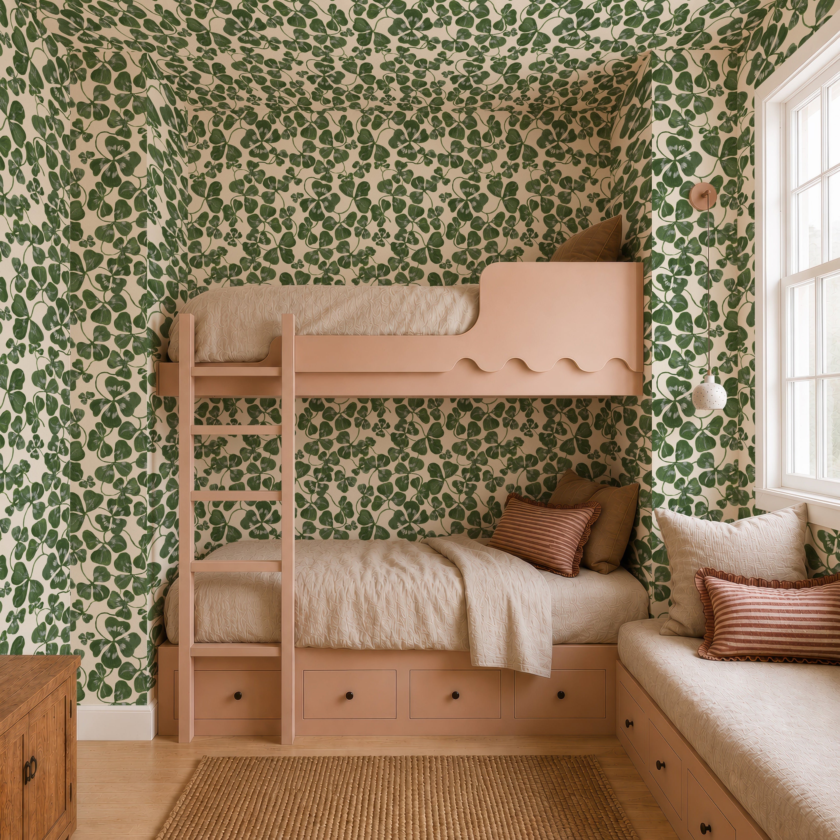 A cozy bedroom features How Lucky We Are Clovers Wallpaper, a peach bunk bed with beige bedding, a window seat with striped cushions, under-bed drawers, and sunlight pouring in from a large window on the right.