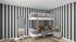 The childrens room displays a sample of munks and mes Circus Stripe Wallpaper Denim with white bunk bed featuring gray bedding, yellow accents, round mirror, lamp on nightstand, woven rug, and toy vehicle. The decor is modern, bright, and playful with black and white vertical stripes.