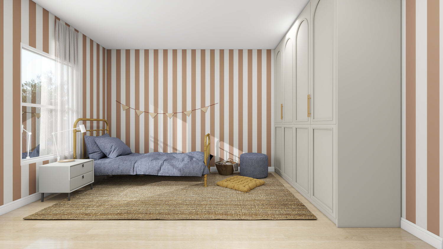A cozy bedroom features munks and me’s Circus Stripe Wallpaper Latte, a small bed with blue bedding, a bedside table, basket, pouf, cushioned floor mat, and a large wardrobe on the right.