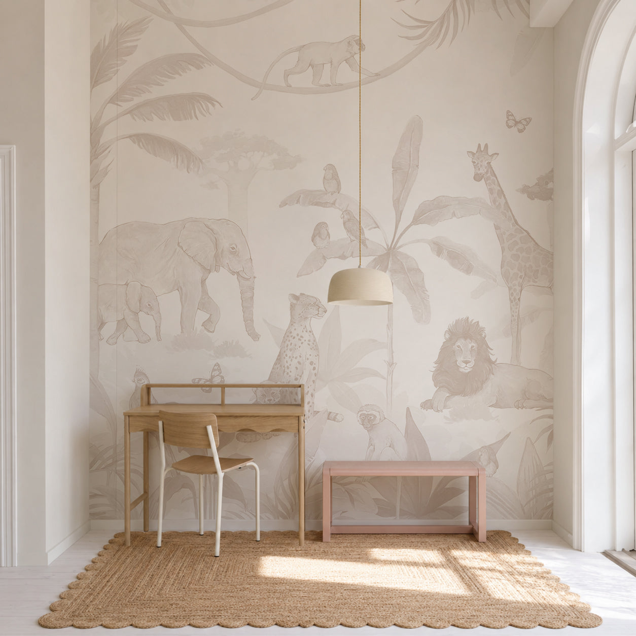 A neutral-toned children’s room with a wooden desk, chair, bench, and a rug features the enchanting African Safari Mural, Neutral—a wall mural depicting safari animals such as an elephant, giraffe, lion, cheetah, and birds among leafy plants.