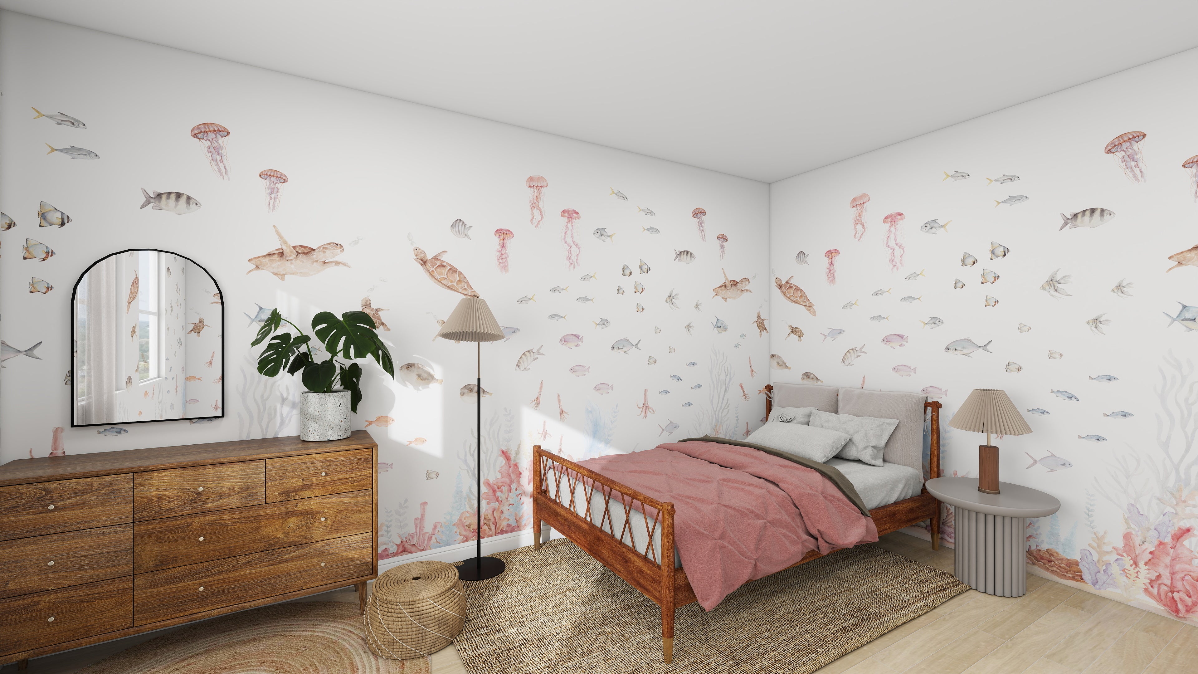 The bedroom features the Fish Tank Wallpaper Mural by munks and me, showcasing an aquatic theme with fish and jellyfish. A wooden bed with pink bedding complements a wooden dresser, two lamps, and a circular mirror. Natural light filters through the window, enhancing this serene space.