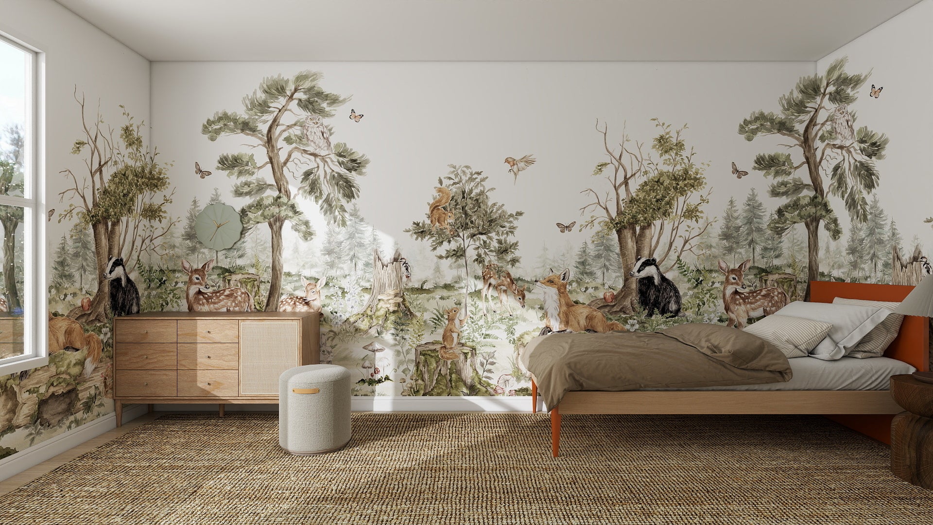 A cozy bedroom features the Into The Forest Wallpaper Mural Sample in stunning quality, showcasing trees, deer, foxes, owls, and butterflies. Sunlight streams onto the bed, nightstand, dresser, and woven rug through a large window.