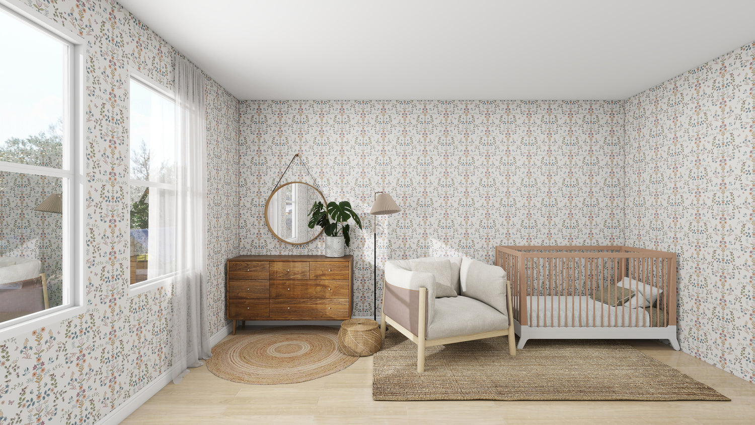 A nursery with Forest Tales wallpaper by munks and me features a wooden crib, beige armchair, and round mirror above the wooden dresser. A floor lamp and large plant in a basket enhance the charm. Light streams through the window onto the jute rug on the wooden floor.