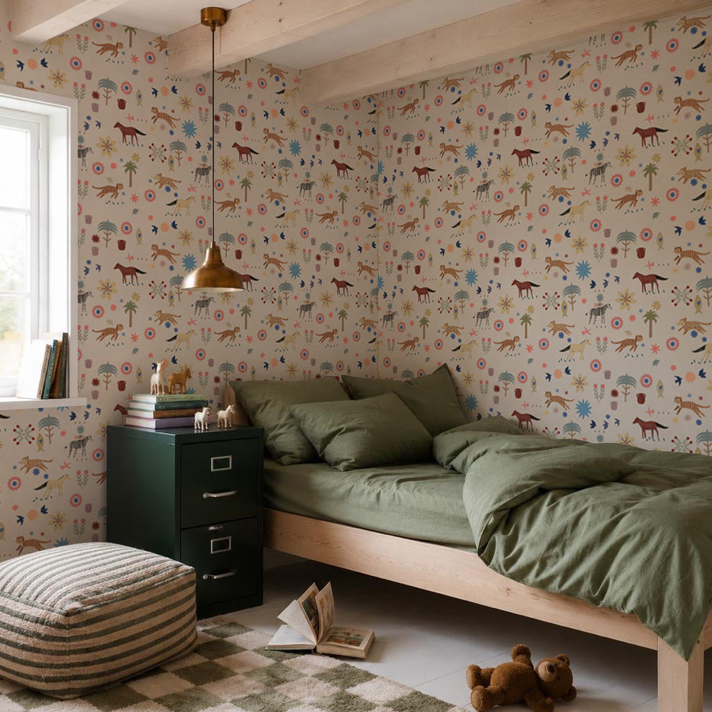 A cozy bedroom with green bedding on a wooden bed, a checkered rug, toys, books, and nursery walls decorated with Little Wanderers Wallpaper featuring colorful animals. Sunlight pours in through the window.