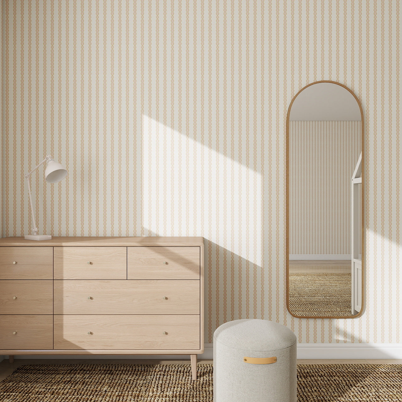 Minimalist room with a light wooden dresser, white desk lamp, oval wall mirror, and round ottoman. Sunlight highlights the Little Abacus Stripe Wallpaper, Pink and Yellow for a playful nursery or kids room accent.