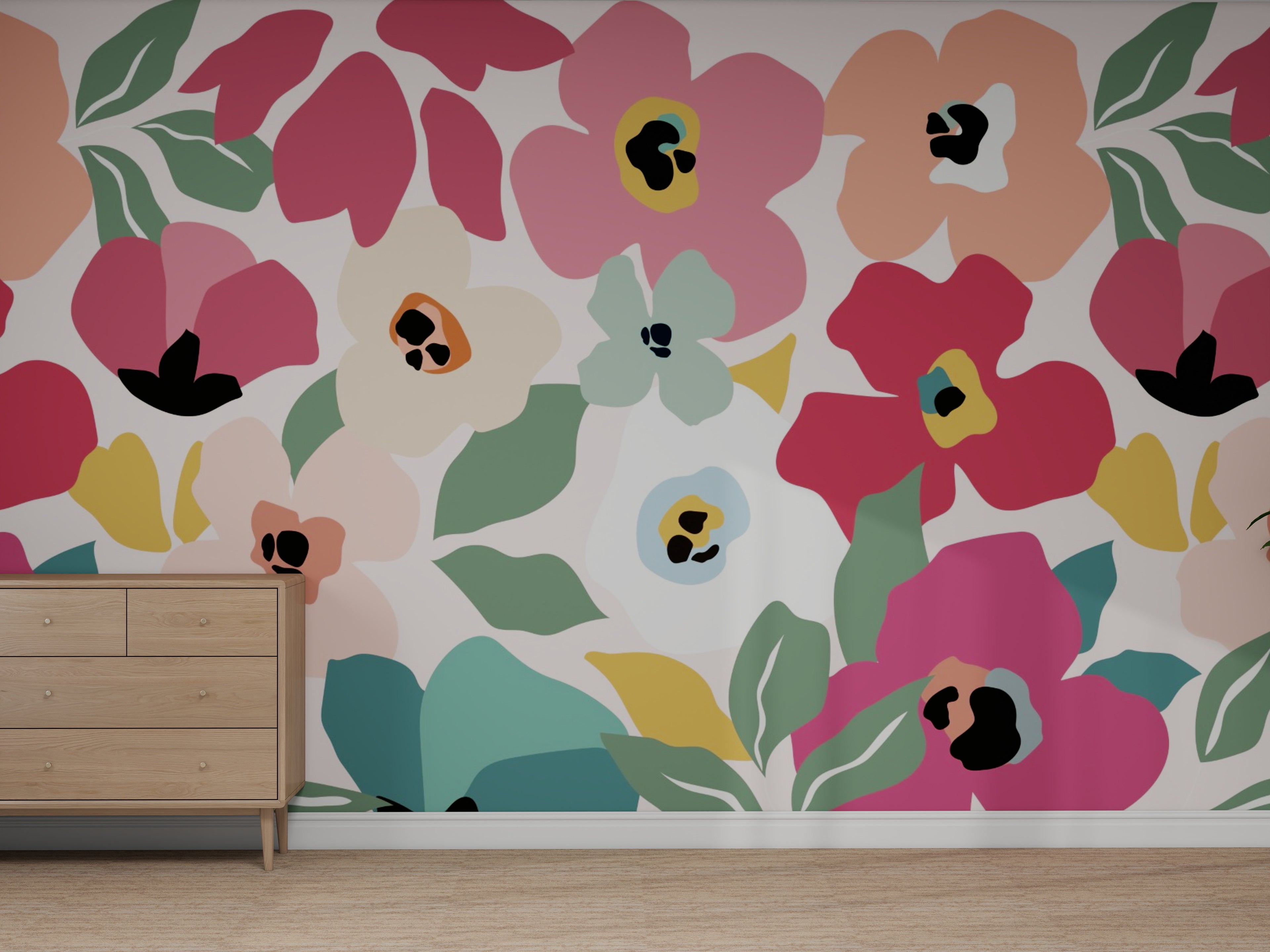 A wall behind a light wood dresser is covered with the Custom Sienna Floral Brights Wallpaper | Repeat Pattern, featuring large, colorful abstract flowers and green leaves above a light brown floor.