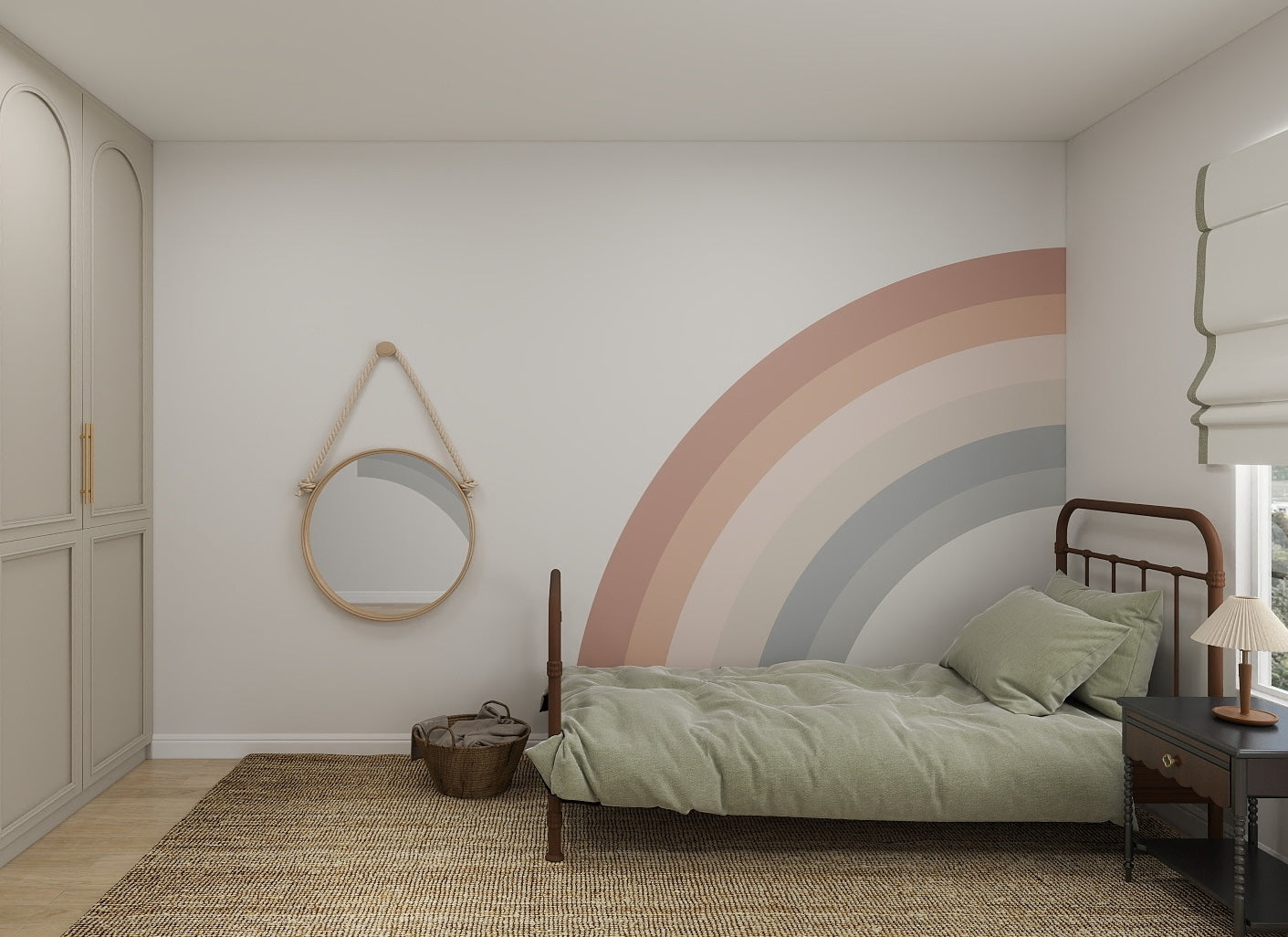 A cozy childrens space featuring a single bed with sage green bedding, a round mirror, woven rug, basket, small dark nightstand with lamp, and the Corner Rainbow Wallpaper Mural as a pastel feature wall.
