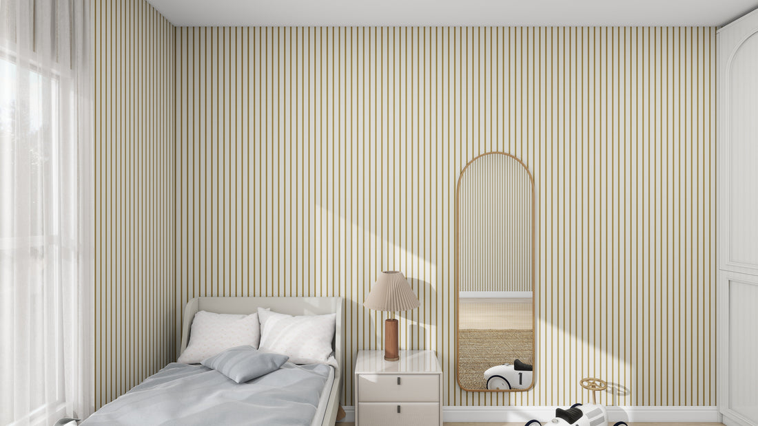 A minimalist bedroom showcases munks and mes Pinstripe Wallpaper Moss sample. A single bed with a blue blanket, white pillows, a bedside table holding a lamp, and a large arched mirror complement the decor. Sunlight filters through curtains, casting gentle shadows.