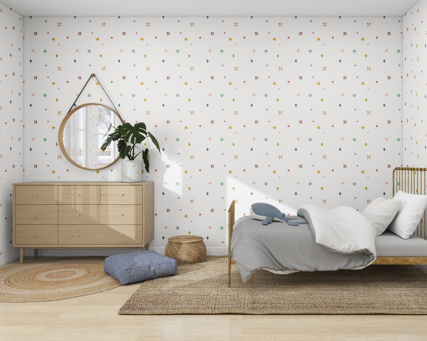 A Scandinavian-inspired bedroom features a light wooden bed with gray bedding, a circular mirror above a sleek dresser with a plant, and a wicker basket on a woven rug. Subtle geometric patterns from the munks and me Pebble and Patch Wallpaper enhance the modern design.