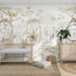 A nursery with a crib and wooden dresser is decorated with the vibrant Safari Savannah Adventure wallpaper from munks and me, showcasing lions, giraffes, and trees. A round mirror above the dresser sits next to a potted plant. On the floor, a woven rug and pouf add coziness.