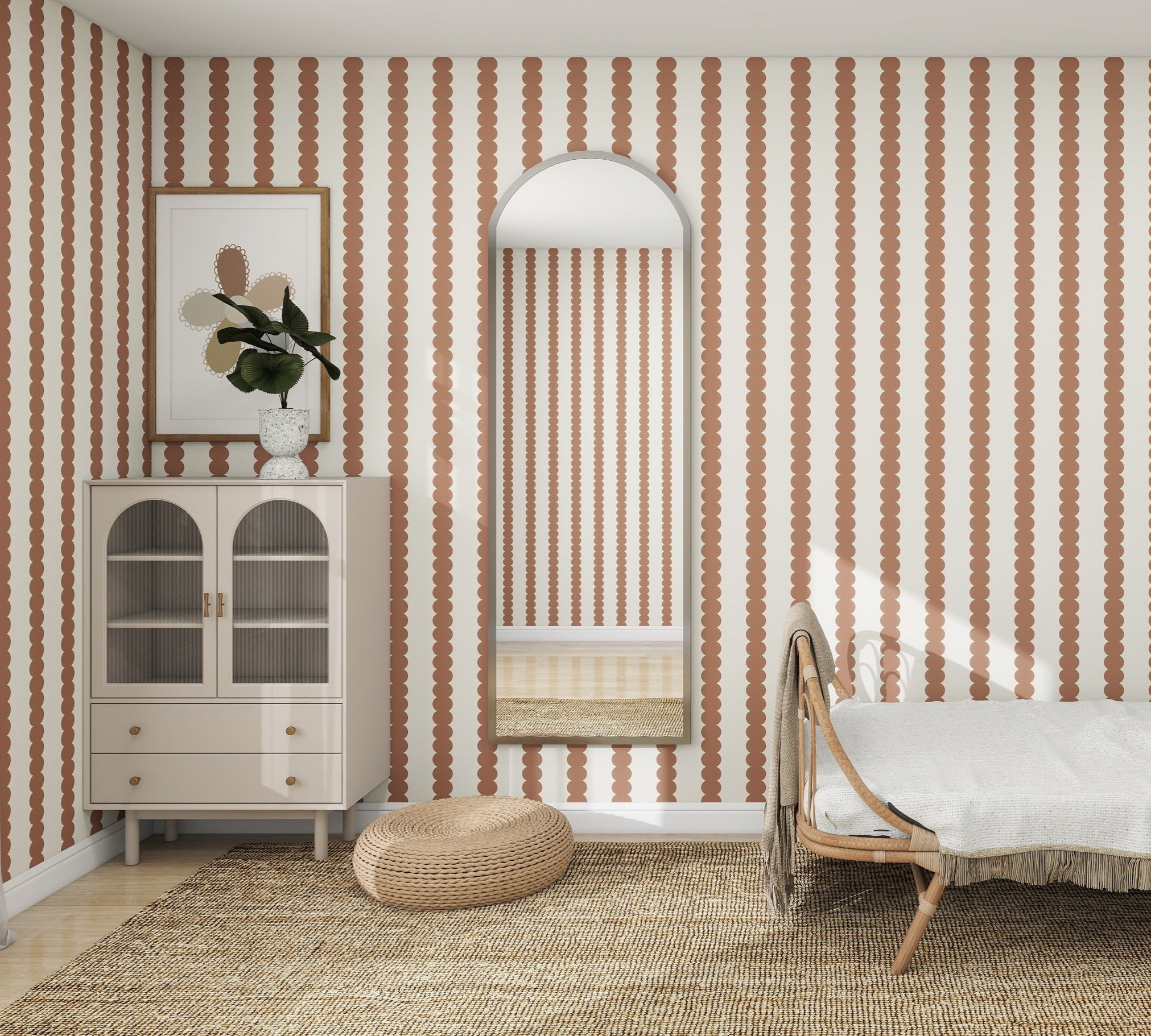 A cozy bedroom includes a rattan headboard bed, Scallop Stripe Wallpaper Mocha from munks and me, and an arch-topped mirror. To the left, theres a cabinet with a potted plant beside a round wicker ottoman in soothing mocha tones, ideal for a nursery.