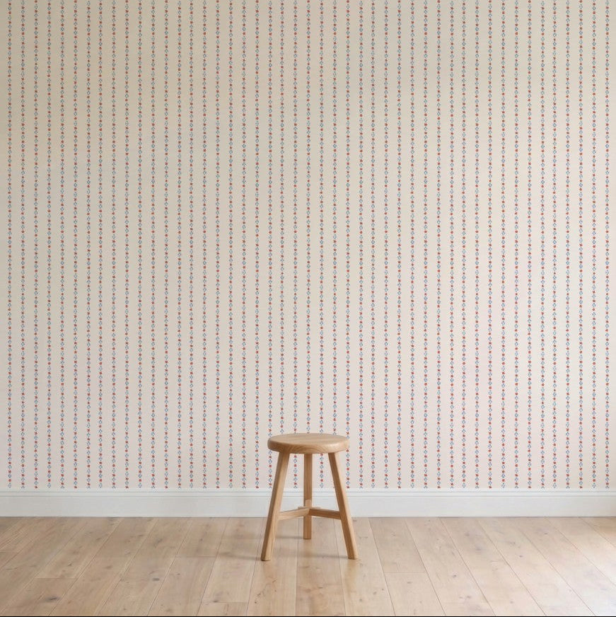 A simple wooden stool stands on a light wood floor against a wall decorated with Jacquard Stars Wallpaper, Red. The scene remains minimalistic and uncluttered.
