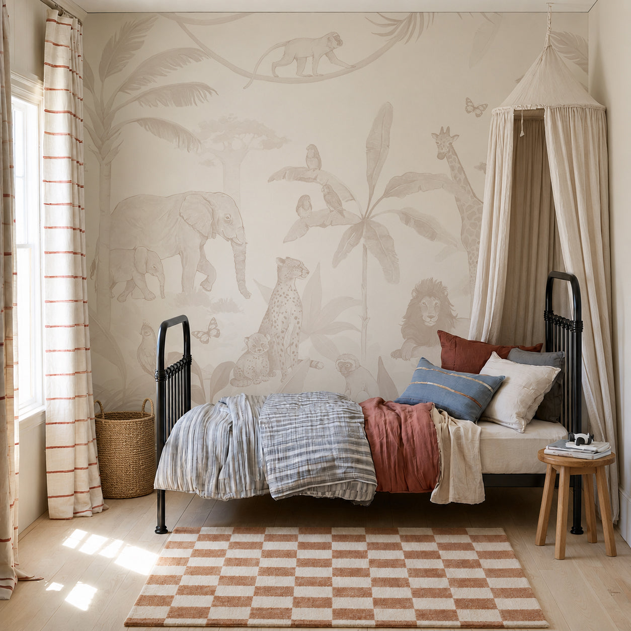 Children’s bedroom with an African Safari Mural, Neutral as a stunning feature wall, showcasing a single bed with layered bedding and a canopy. The room is styled with a round stool, wicker basket, and checkered rug atop a light wooden floor. Sunlight pours in through the window dressed in striped curtains, completing this playful children’s room decor.