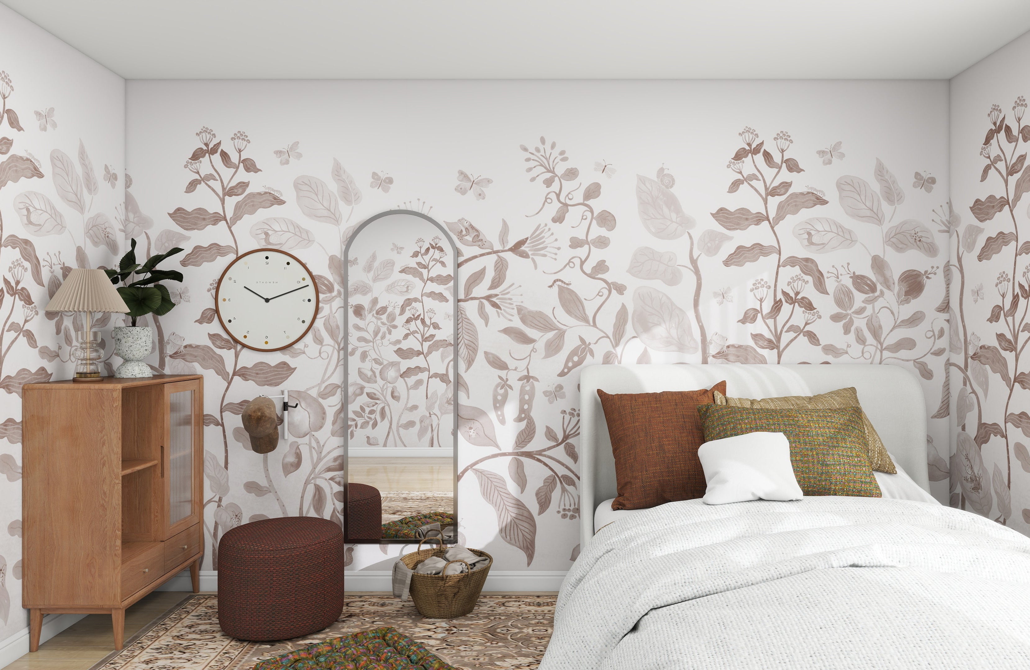 A cozy bedroom reminiscent of a whimsical world features munks and mes Secret Garden Wallpaper Mural Mocha. A bed with white bedding and patterned pillows rests against it. The room includes a wooden cabinet with a lamp, a round pouf, an oval mirror, a clock, and decorative plants.