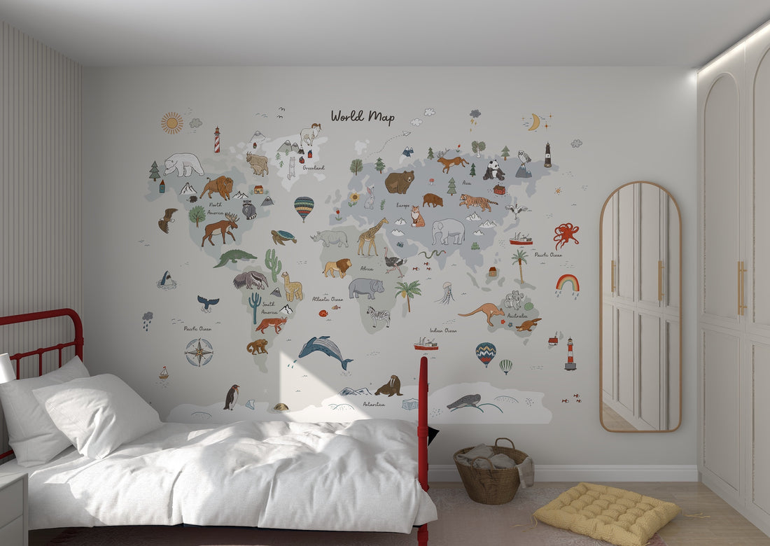 A cozy bedroom with a red-framed bed on the left showcases the World Map Wallpaper Grey by munks and me, adorned with animals and landmarks. A mirrored wardrobe is on the right, while a toy-filled woven basket rests on the light wooden floor enhancing the rooms charm.