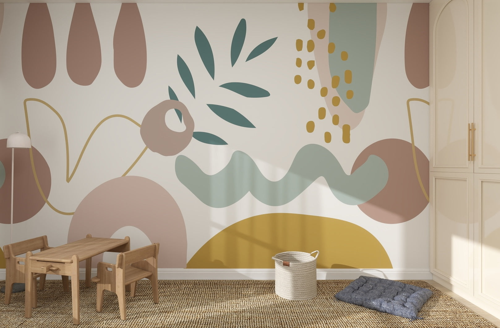 A children’s playroom featuring a small wooden table and chairs, floor lamp, basket, two blue cushions, and the Abstract Wallpaper Mural with colorful organic shapes adding whimsy to the wall.