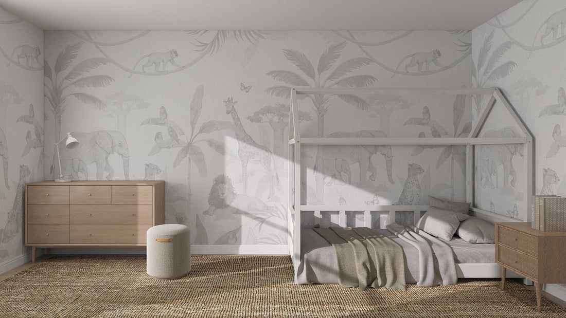 A minimalistic children’s bedroom featuring an African Safari Wallpaper Mural in grey with elephants, giraffes, and monkeys, complemented by a house-shaped bed frame, neutral bedding, and wooden furniture.