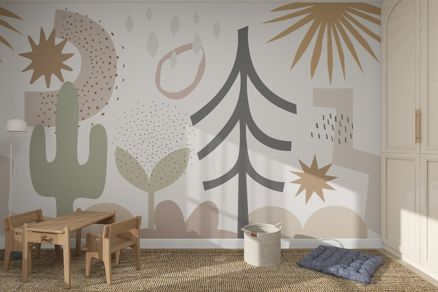 Children’s playroom with the Audrey Abstract Wallpaper Mural featuring plants, stars, and shapes in muted earth tones. A wooden table and chairs, floor lamp, woven rug, basket, and blue floor cushion complete this cozy kids room.