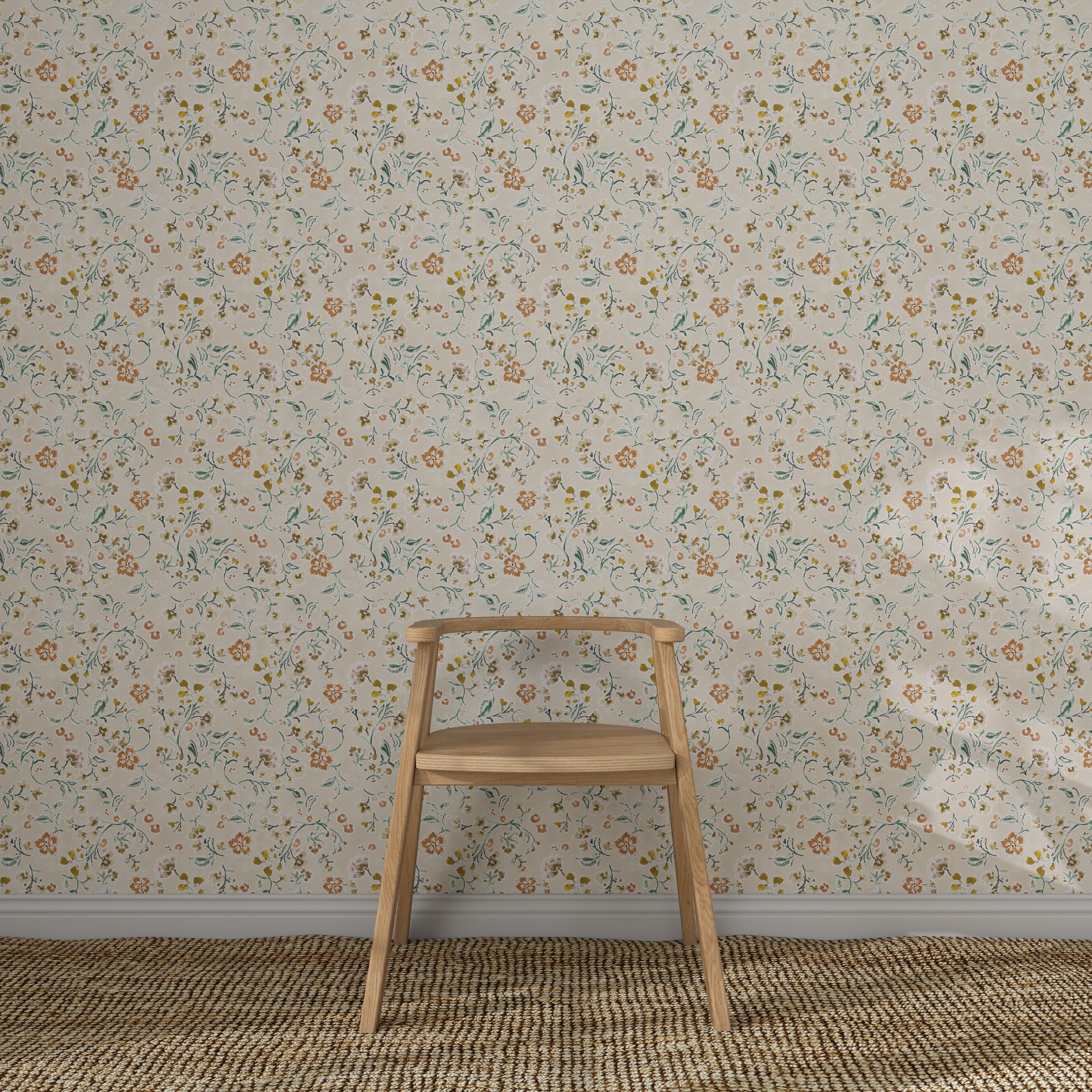 A simple wooden chair sits on a textured woven rug in front of a wall adorned with Terra Bloom Wallpaper, featuring light-colored, hand-painted floral patterns with small orange and blue flowers.
