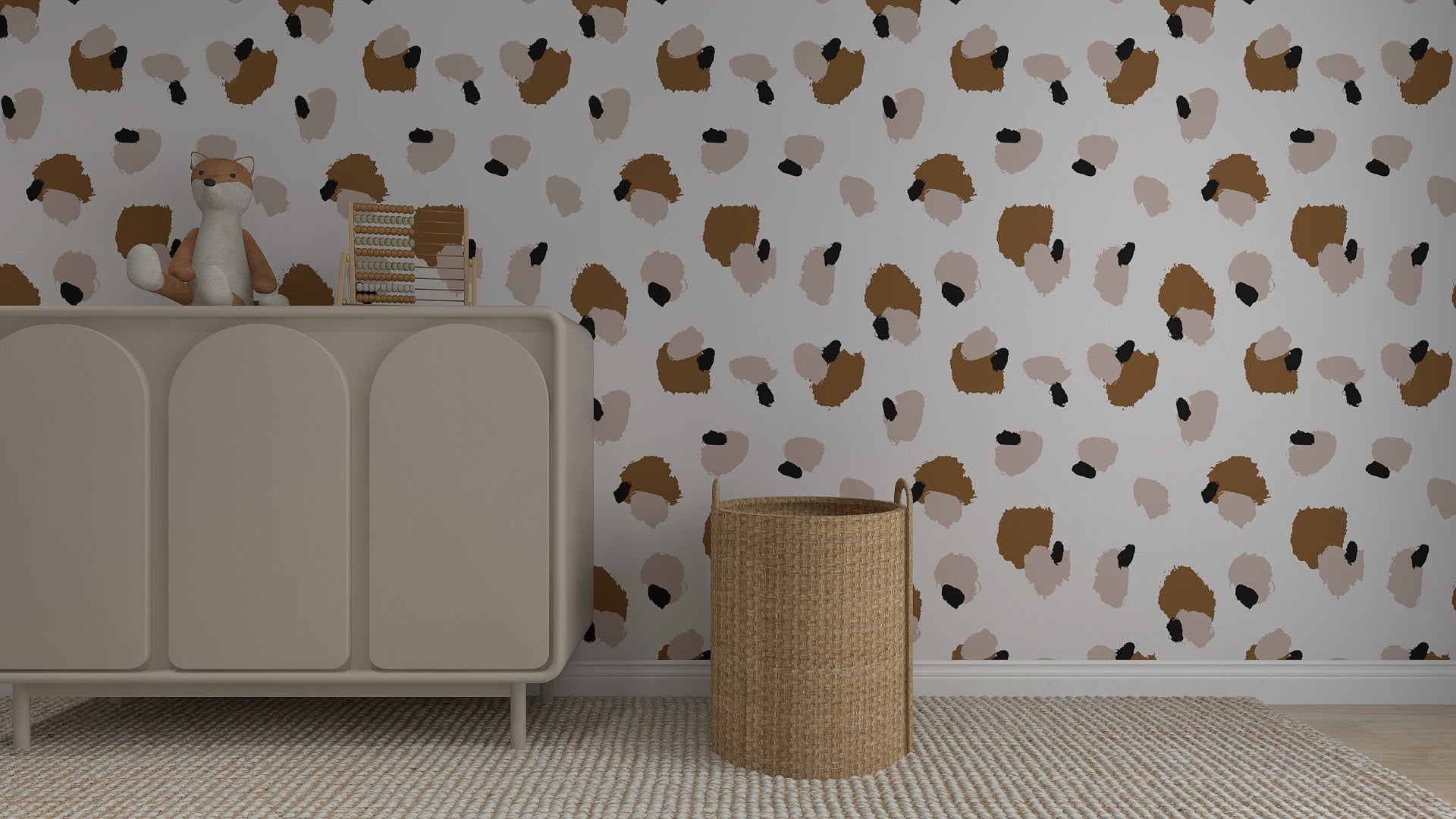A nursery with a beige dresser holding a plush fox and books, a wicker basket on the right, and whimsical home decor featuring Harry Leopard Print Wallpaper Repeat Pattern in brown, beige, and black. A textured beige rug covers the floor.
