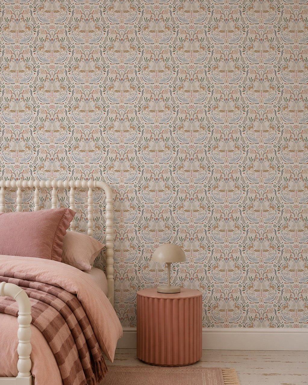 A cozy bedroom featuring the Creatures Great and Small Wallpaper in soft pastels, a cream spindle bed, pink and beige bedding, plus a round ribbed bedside table with a modern lamp for a whimsical touch.