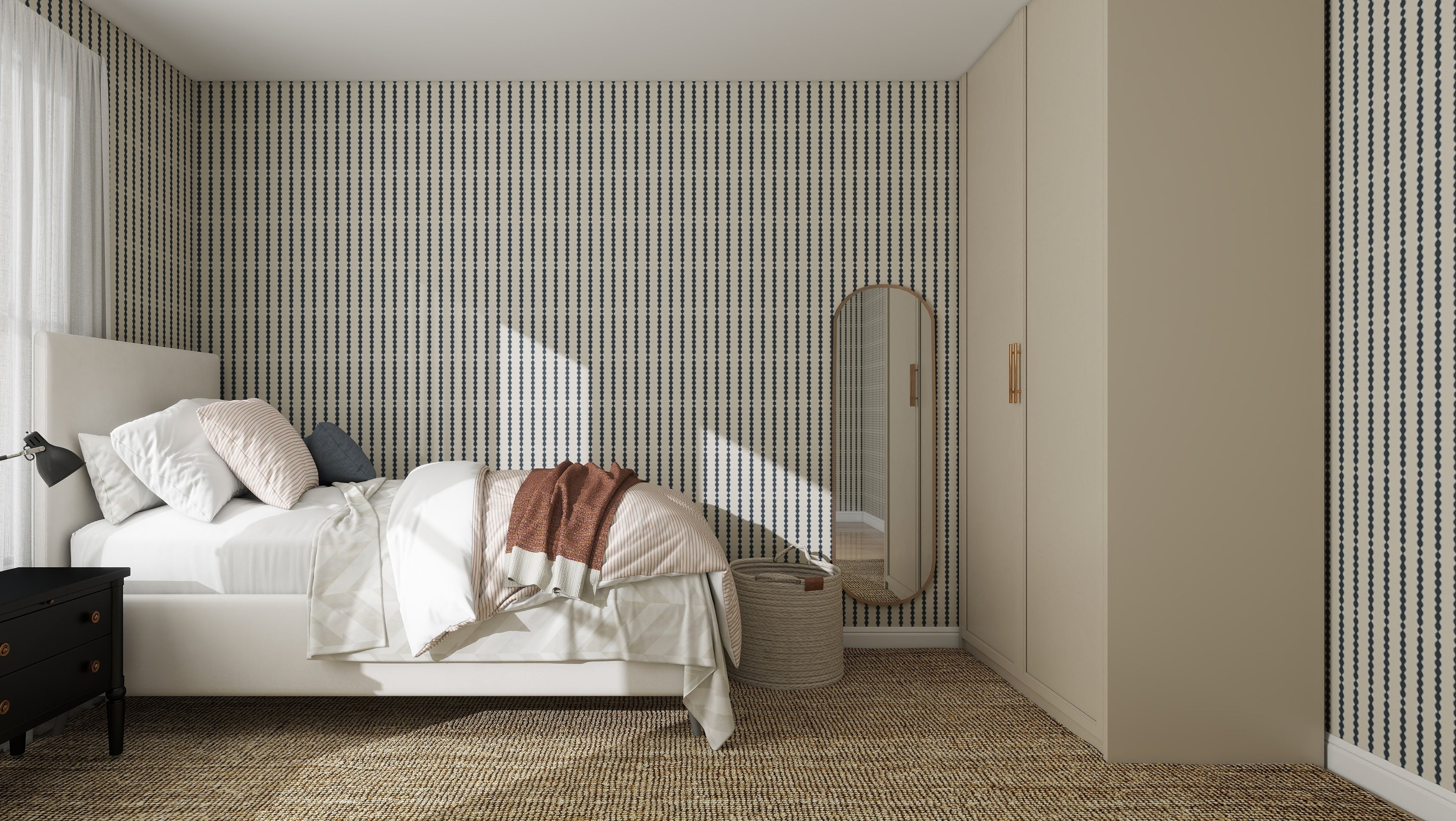 A modern bedroom features a bed with white linens, a black nightstand and lamp, full-length mirror, woven basket, beige wardrobes, and quality Little Abacus Stripe Denim Wallpaper. Natural light streams through the window.