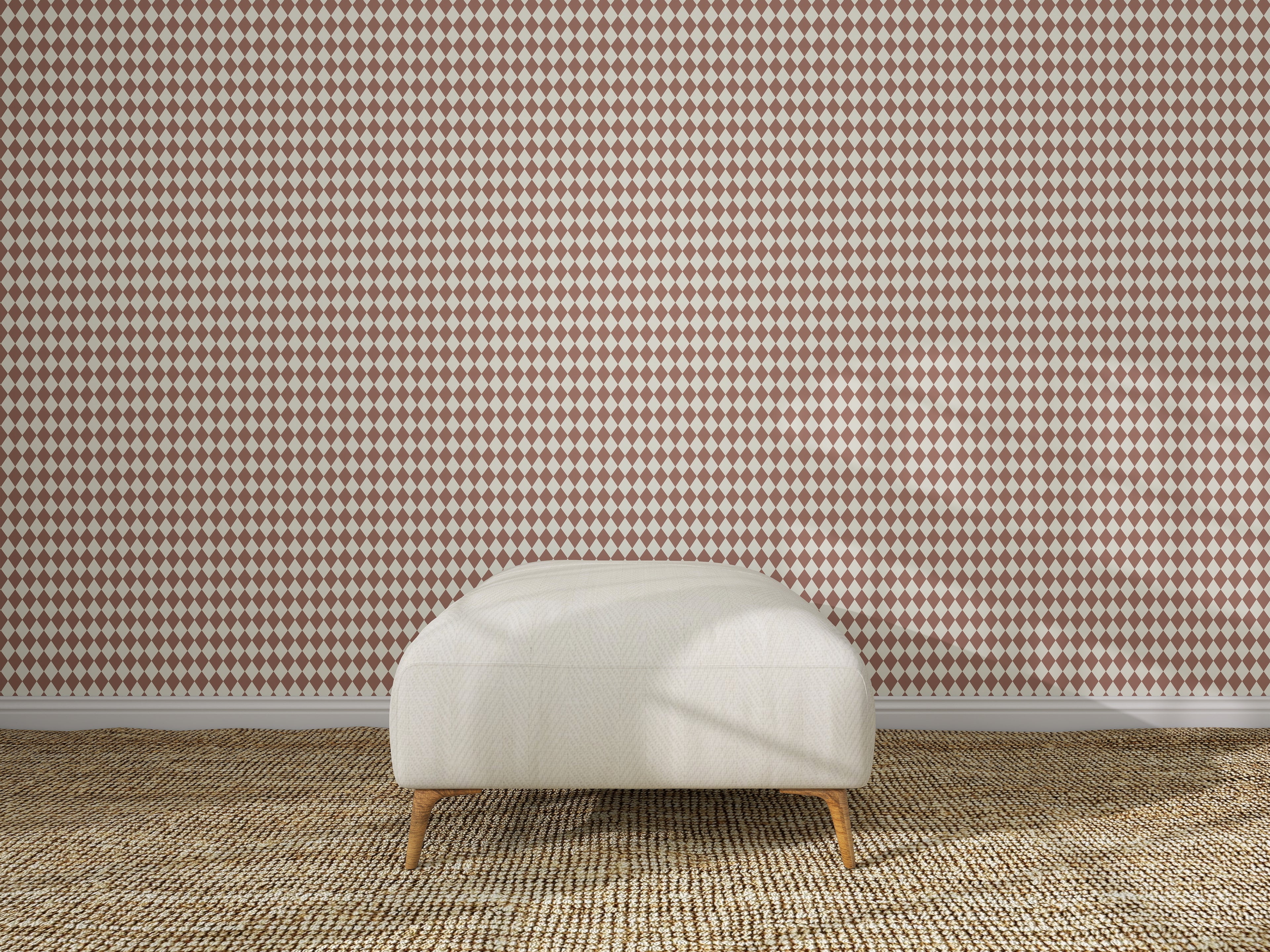 A white cushioned bench with wooden legs sits on a beige woven rug, set before a wall decorated with Diamond Dancer Wallpaper in the Stone Rose colorway.