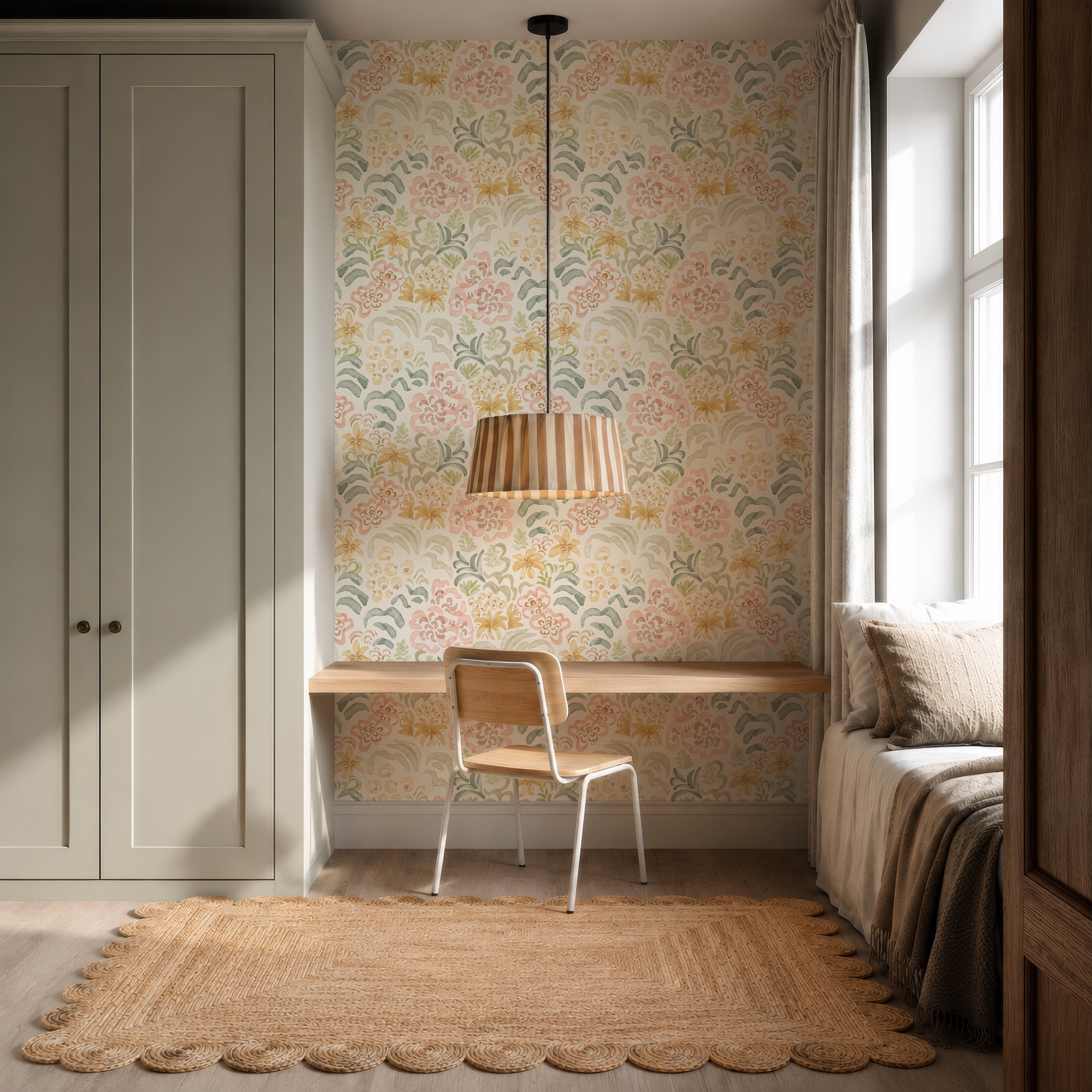 Cozy study nook with a wooden desk, white chair, and pendant light. The space features Floret Dreamscape Wallpaper for a whimsical touch, a large window with curtains, a cushioned window seat with pillows, and a scalloped jute rug to complete the look.