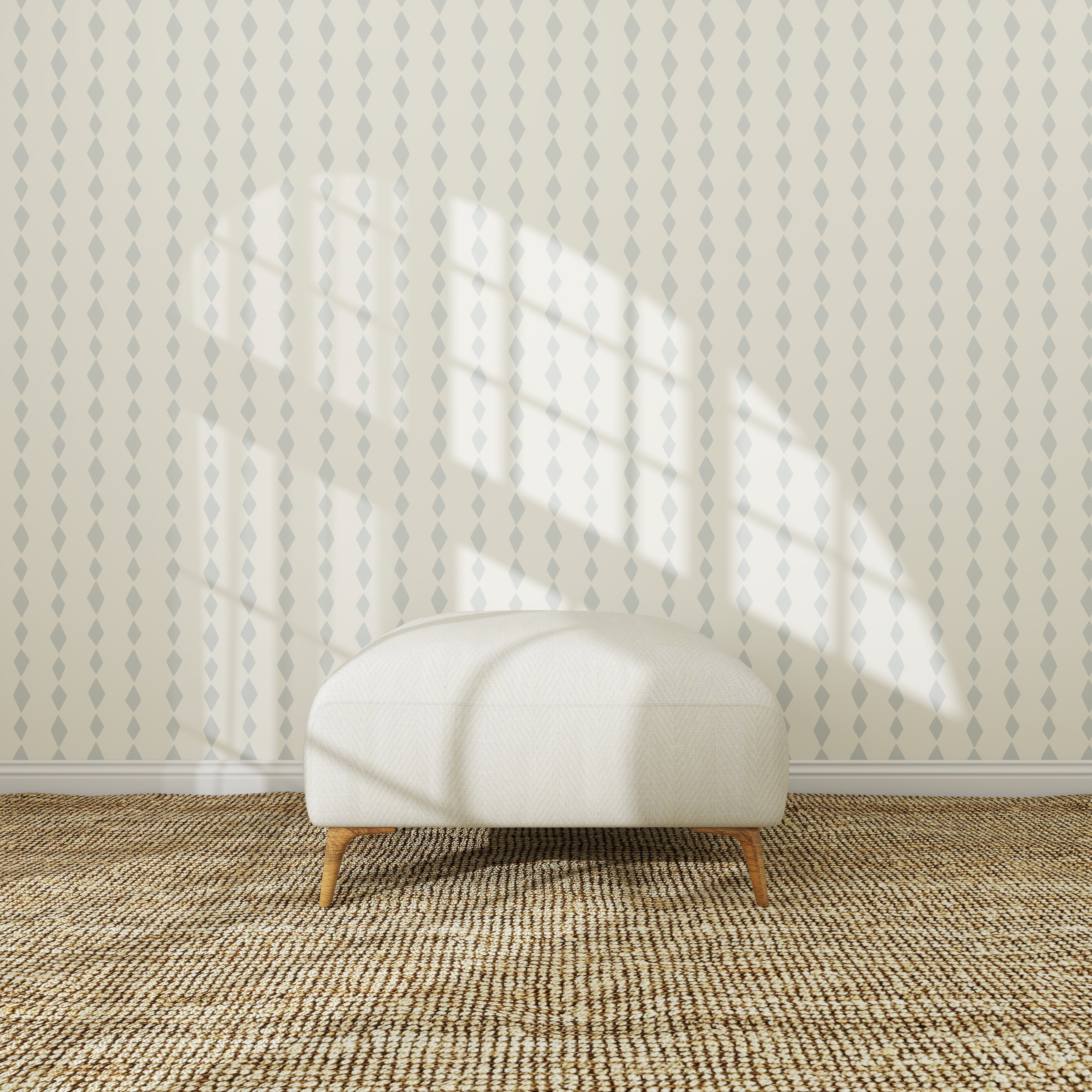 A white oval ottoman with wooden legs sits on a textured carpet in front of Jolly Jester Wallpaper Repeat Blue, as sunlight highlights the wallpaper and casts window shadows, creating a bright and cozy atmosphere.