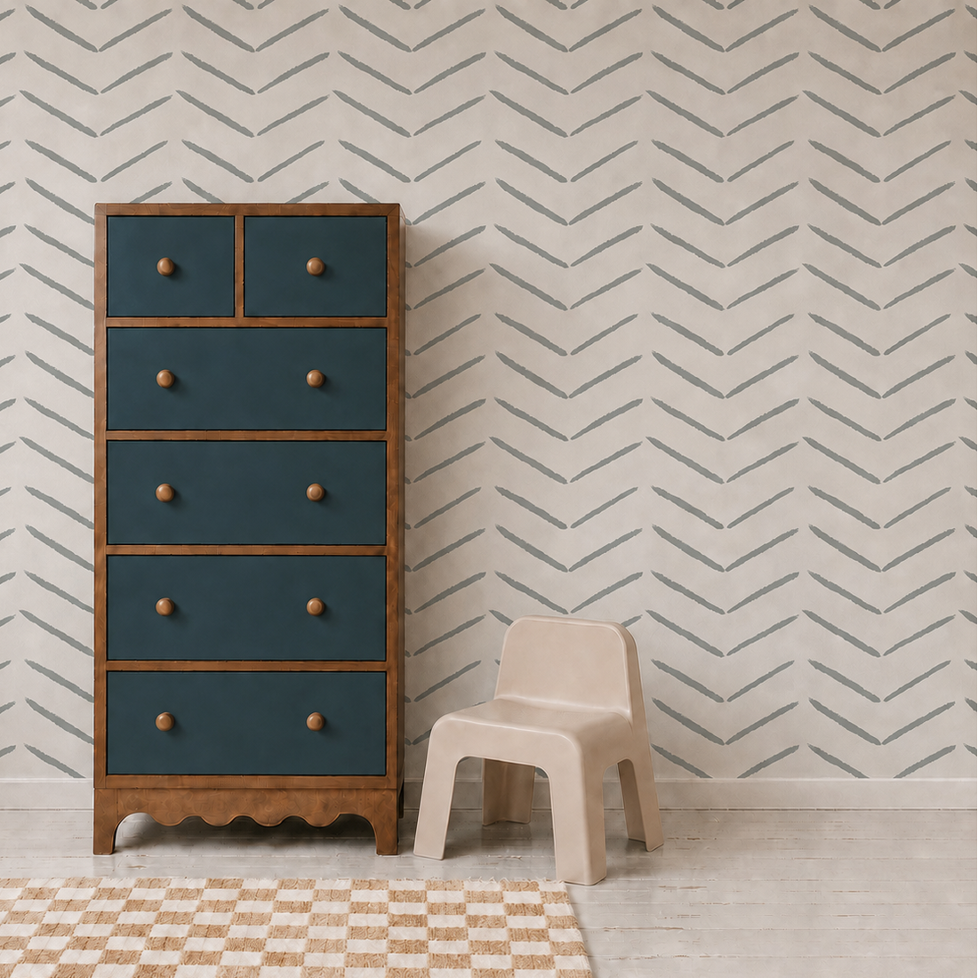 A tall wooden dresser with blue drawers stands beside a small beige plastic chair in a room decorated with Herringbone Wallpaper, Blue, and featuring a checkered rug on the light wooden floor.