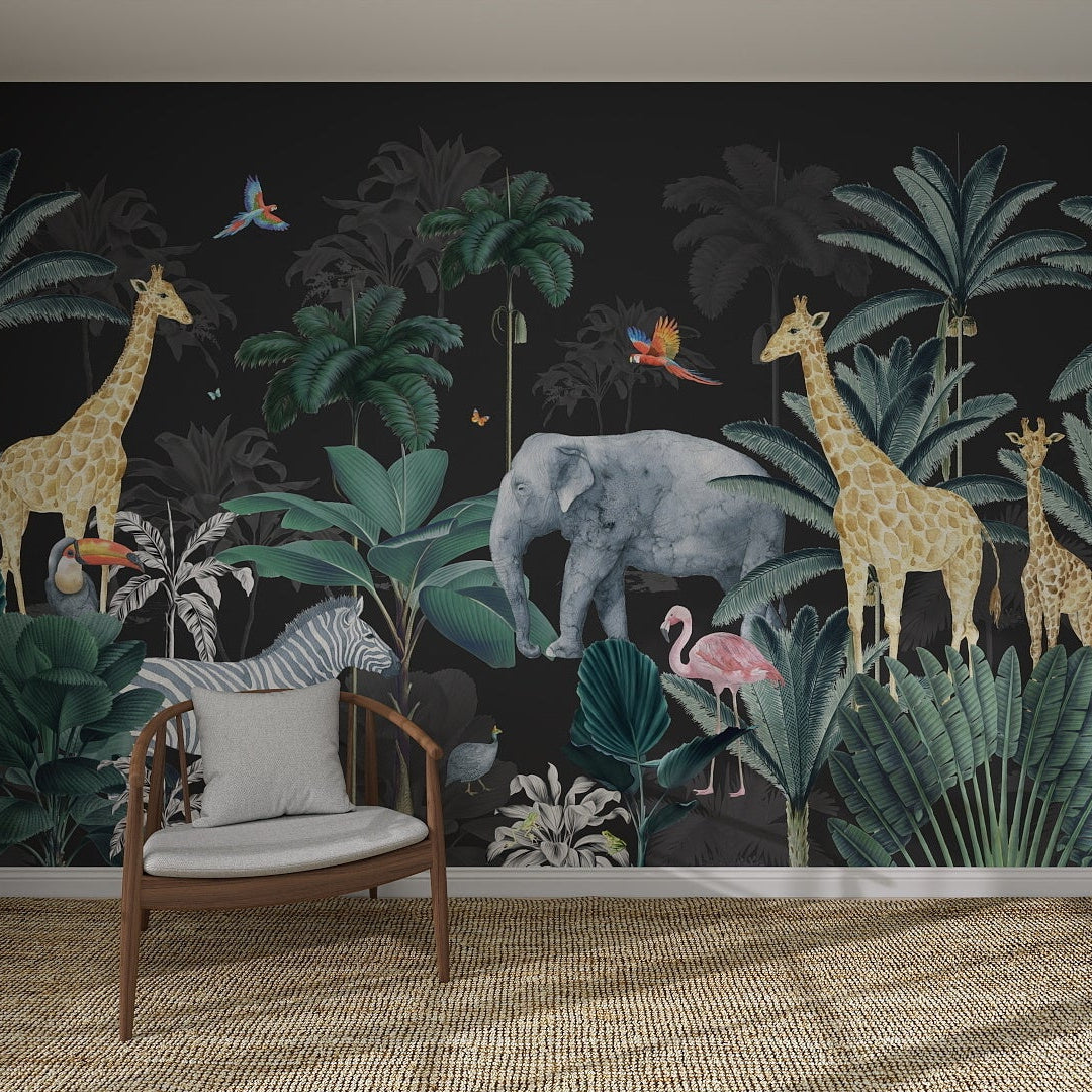 A neutral chair and cushion sit before the Charcoal Jungle Wallpaper | Sample, which features lush tropical plants, illustrated giraffes, an elephant, flamingos, and parrots—all showcased beautifully in a modern room with a woven rug.