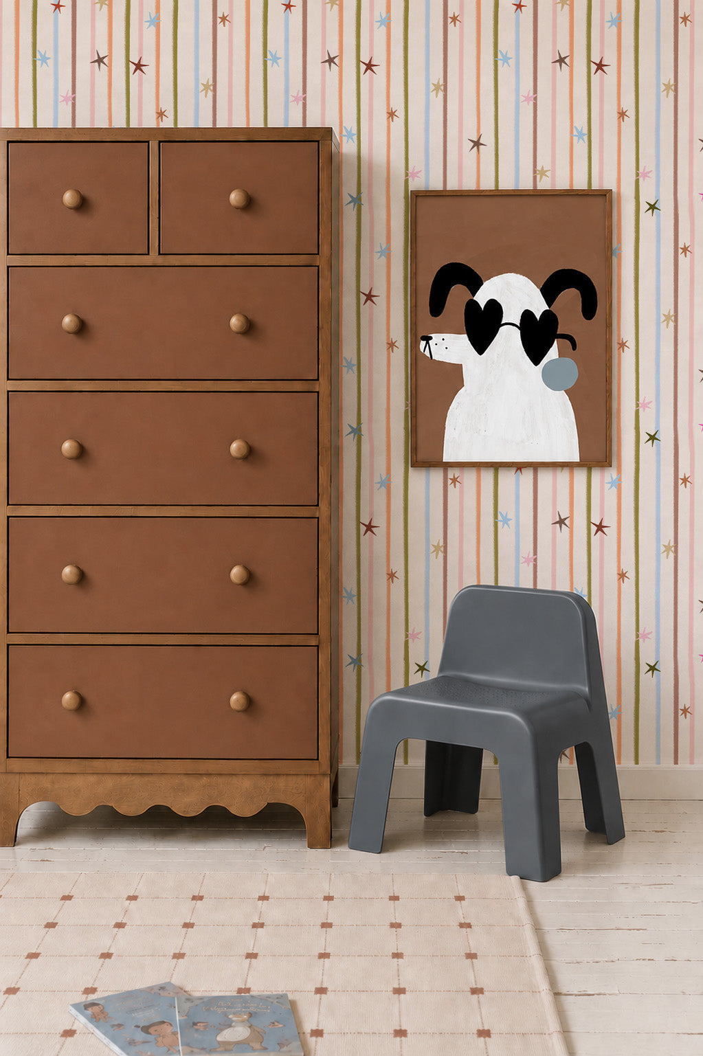 A tall wooden dresser stands next to a gray plastic chair and a framed print of a white dog in heart-shaped sunglasses, set against Starlight Stripe Wallpaper featuring vertical colorful stripes and scattered stars.