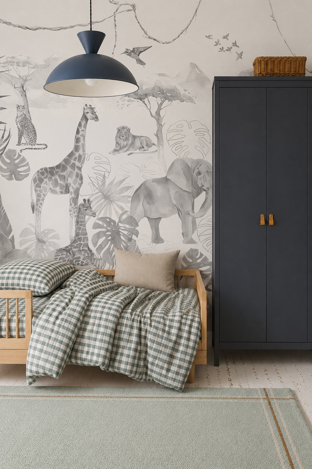A child’s room with a wooden bed, plaid bedding, gray wardrobe, and the Paradise Jungle Mural, Monochrome featuring illustrated safari animals. A woven basket on the wardrobe adds charm to the children’s decor.