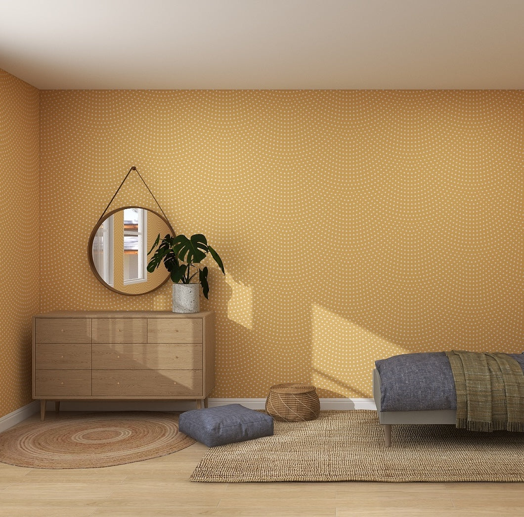 A minimalist bedroom with Scallop Shell Wallpaper Repeat Pattern | Yellow, a wooden dresser with a round mirror and potted plant, a low bed with gray bedding, woven rugs, and floor cushions. Natural light fills the room.