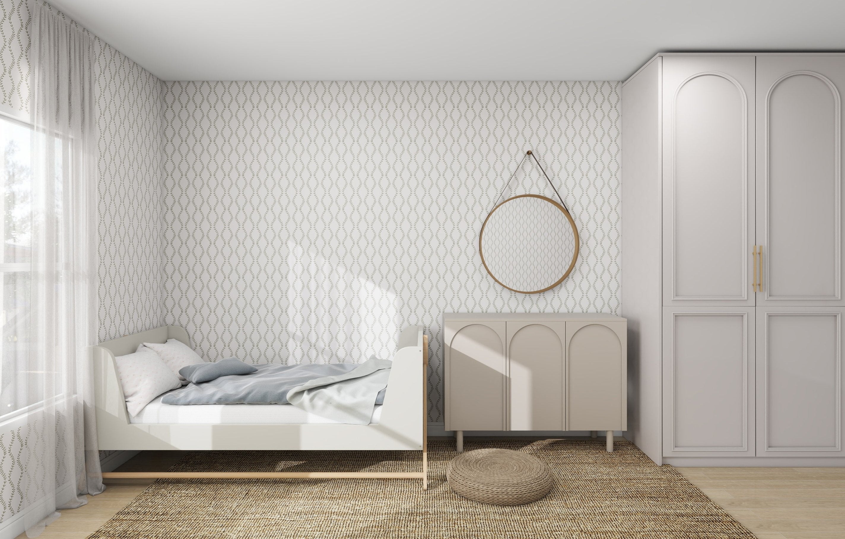 A minimalist bedroom showcases a white toddler bed with a blue blanket and pillow. Charm is added to the walls with Vintage Vines Wallpaper Repeat Pattern by munks and me. A round mirror hangs above a beige dresser, and light from a large window illuminates the woven rug and storage cabinet.