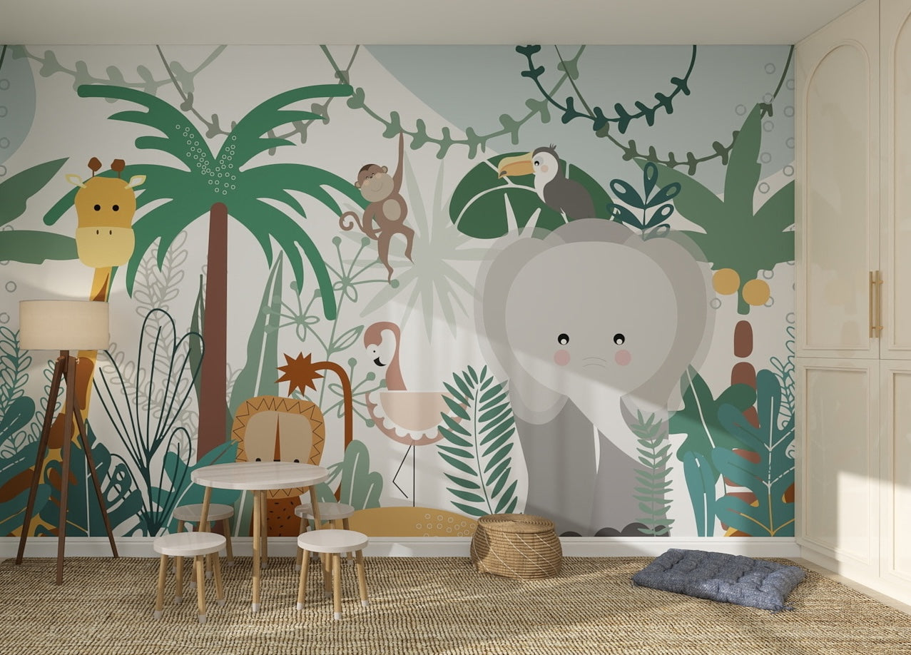 A children’s playroom features Safari Wallpaper | Sample in vibrant jungle colors with cartoon animals like an elephant, giraffe, and toucan. Small tables, chairs, wicker baskets, and cushions on a woven rug enhance the wallpaper’s quality.