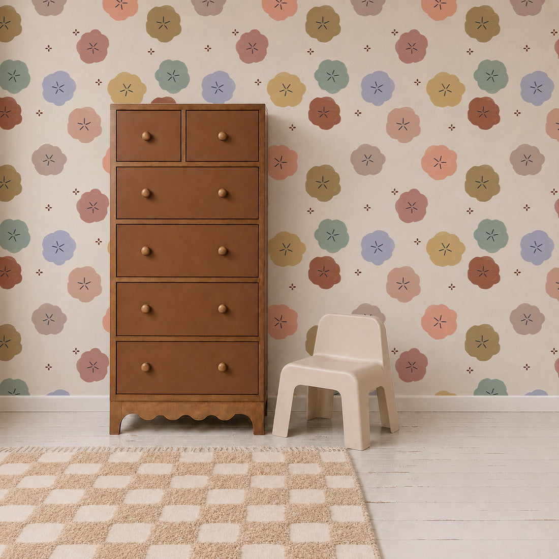 A tall brown dresser and a small beige chair sit on a light wood floor with a checkered rug, against a wall decorated with Posy Pop Wallpaper in pastel hues, perfect for creating a charming and whimsical space.