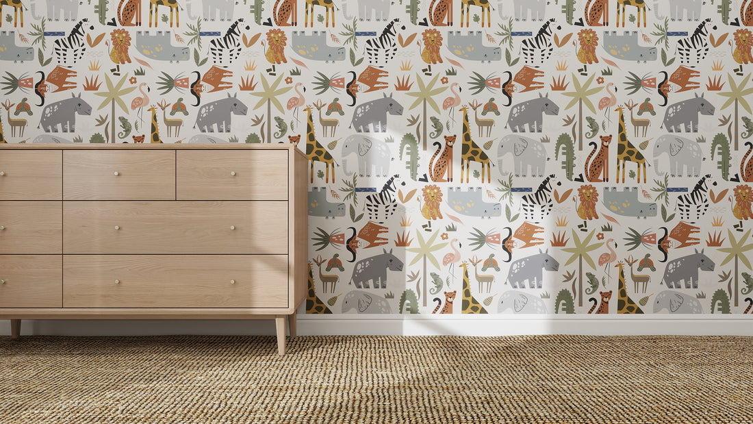 A light wood dresser stands on a woven carpet before a wall decorated with Safari Tetris Wallpaper Repeat Pattern, featuring giraffes, elephants, zebras, plants, and abstract shapes—ideal for sparking imagination in kids’ rooms.