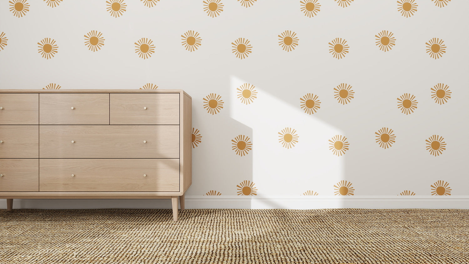 A light wooden dresser stands on a woven rug in a white-walled room, decorated with Shining Sun Wallpaper Repeat Pattern. Sunlight streams in, casting shadows across the wall and floor.