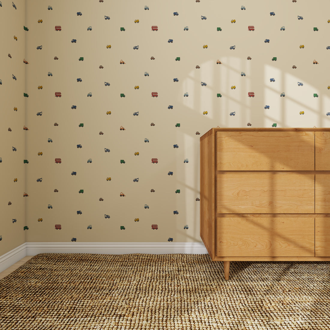 A minimalist room features the Transport Trail Wallpaper Sample in beige, decorated with small, colorful car and truck patterns. A light wood dresser stands on a textured woven carpet as sunlight casts window shadows on the wall and dresser.