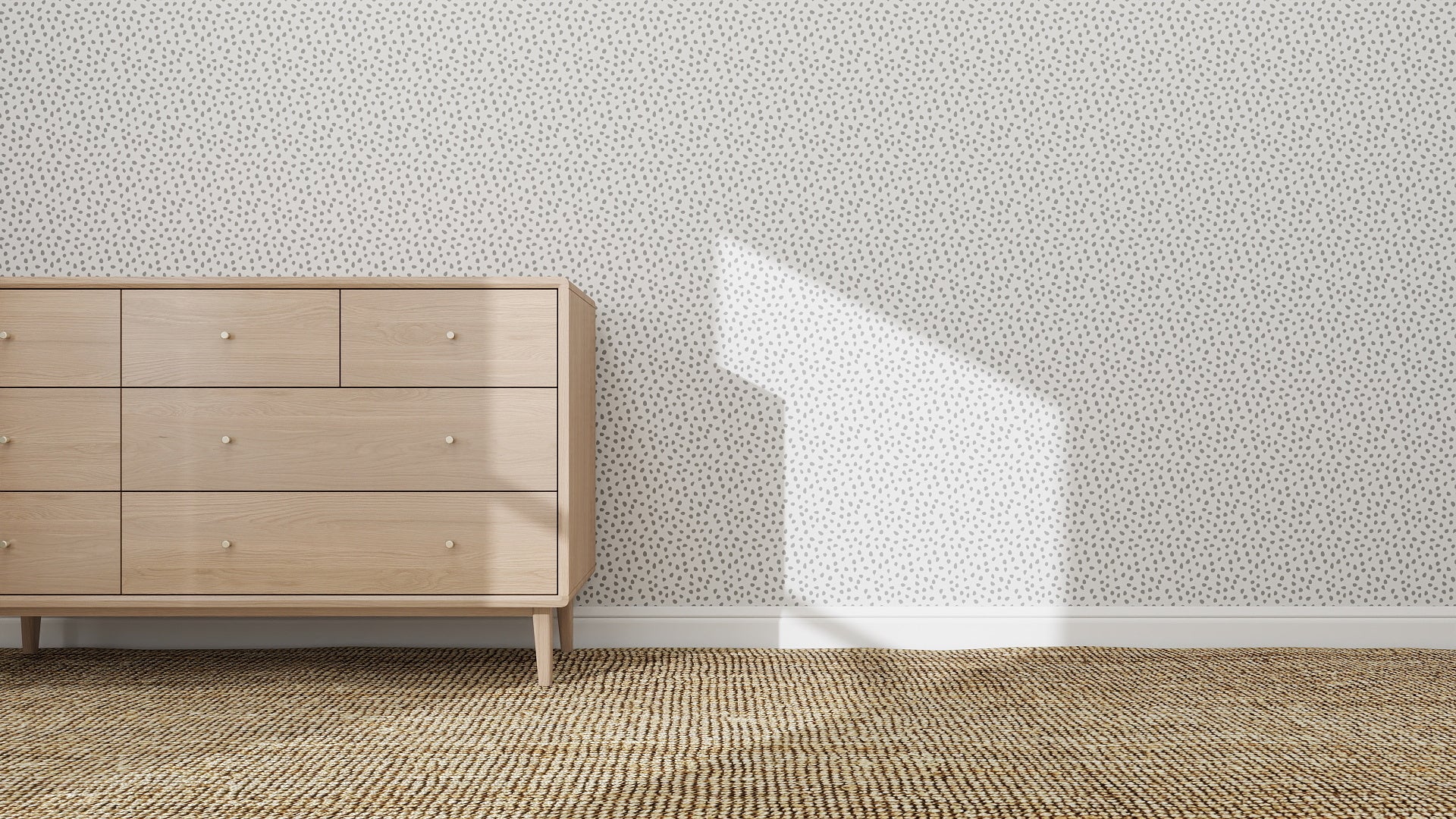 A light wooden dresser stands against Sprinkle Wallpaper Repeat Pattern | Grey. Sunlight casts geometric shadows on the wall and carpeted floor, adding dimension to the minimalist, mid-century modern design.