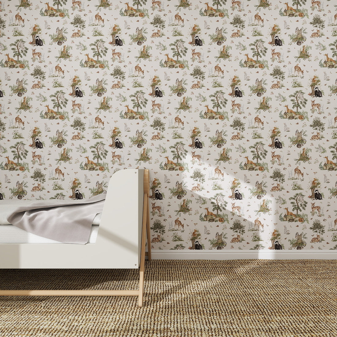 A children’s bedroom features a white wooden bed, light gray blanket, beige carpet, and is enhanced by the Tales Beneath The Trees Wallpaper Cream—an illustrated design of animals and plants in muted tones for a serene atmosphere.