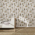 A children’s bedroom features a white wooden bed, light gray blanket, beige carpet, and is enhanced by the Tales Beneath The Trees Wallpaper Cream—an illustrated design of animals and plants in muted tones for a serene atmosphere.