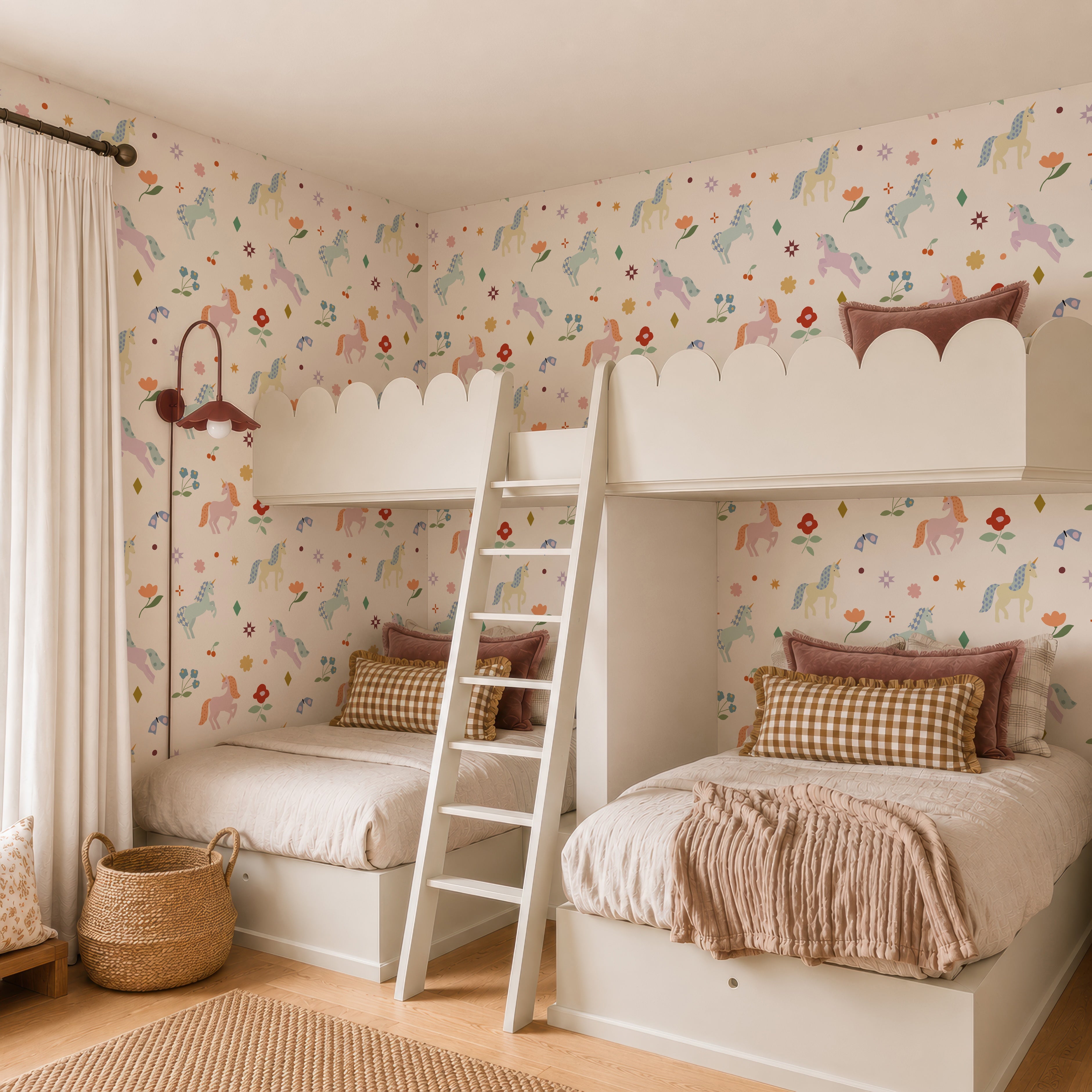 Children’s bedroom featuring two white bunk beds with pastel bedding, a wooden ladder, the Unicorn Party Wallpaper, a wicker basket, and a window with cream curtains for a cozy, whimsical vibe.