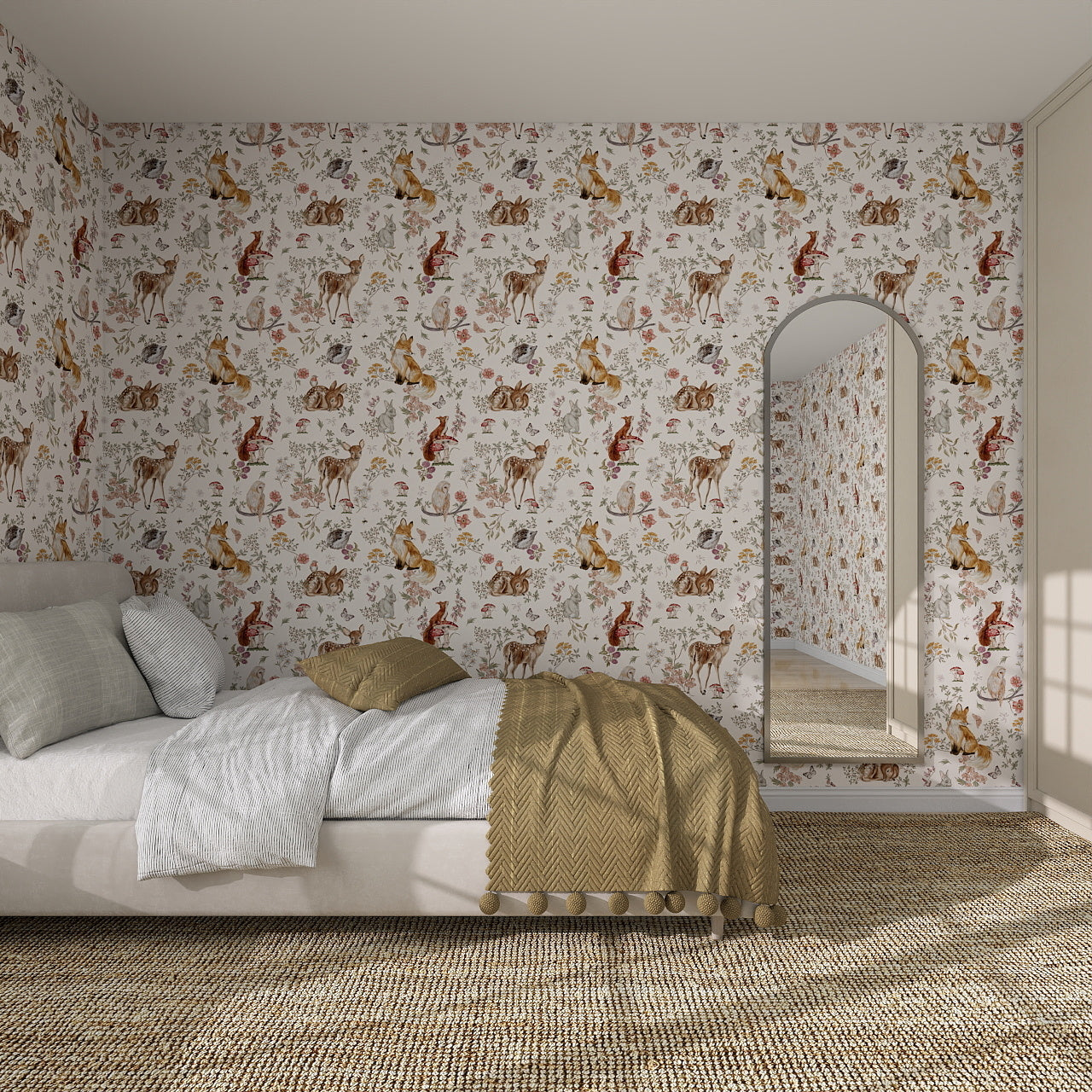A cozy bedroom with a low bed, white bedding, and a mustard throw features Whimsical Woodland Wallpaper on the walls. A large arched mirror reflects the playful design, while a woven rug adds warmth to the floor.