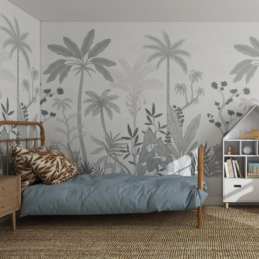 A cozy, modern bedroom features Natural Wonder Palm Wallpaper Mural Slate, a rattan rug, single bed with blue bedding, wooden furniture, bookshelves, potted plants, and a large window filling the space with natural light.
