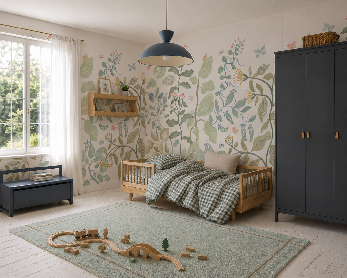Cozy children’s bedroom with a wooden bed, green checkered bedding, the Secret Garden Mural creating a charming floral wall feature, blue wardrobe, toy train set on a green rug, window with white curtains, and natural light streaming in.