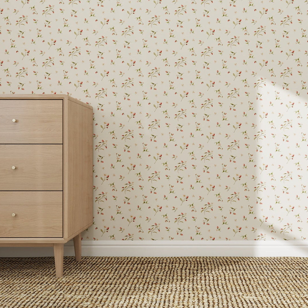 A light wooden dresser stands on a woven carpet beside a wall decorated with Berry and Bramble Wallpaper Repeat Pattern. Sunlight from an unseen window highlights the wallpaper, casting a bright square of light onto its floral design.