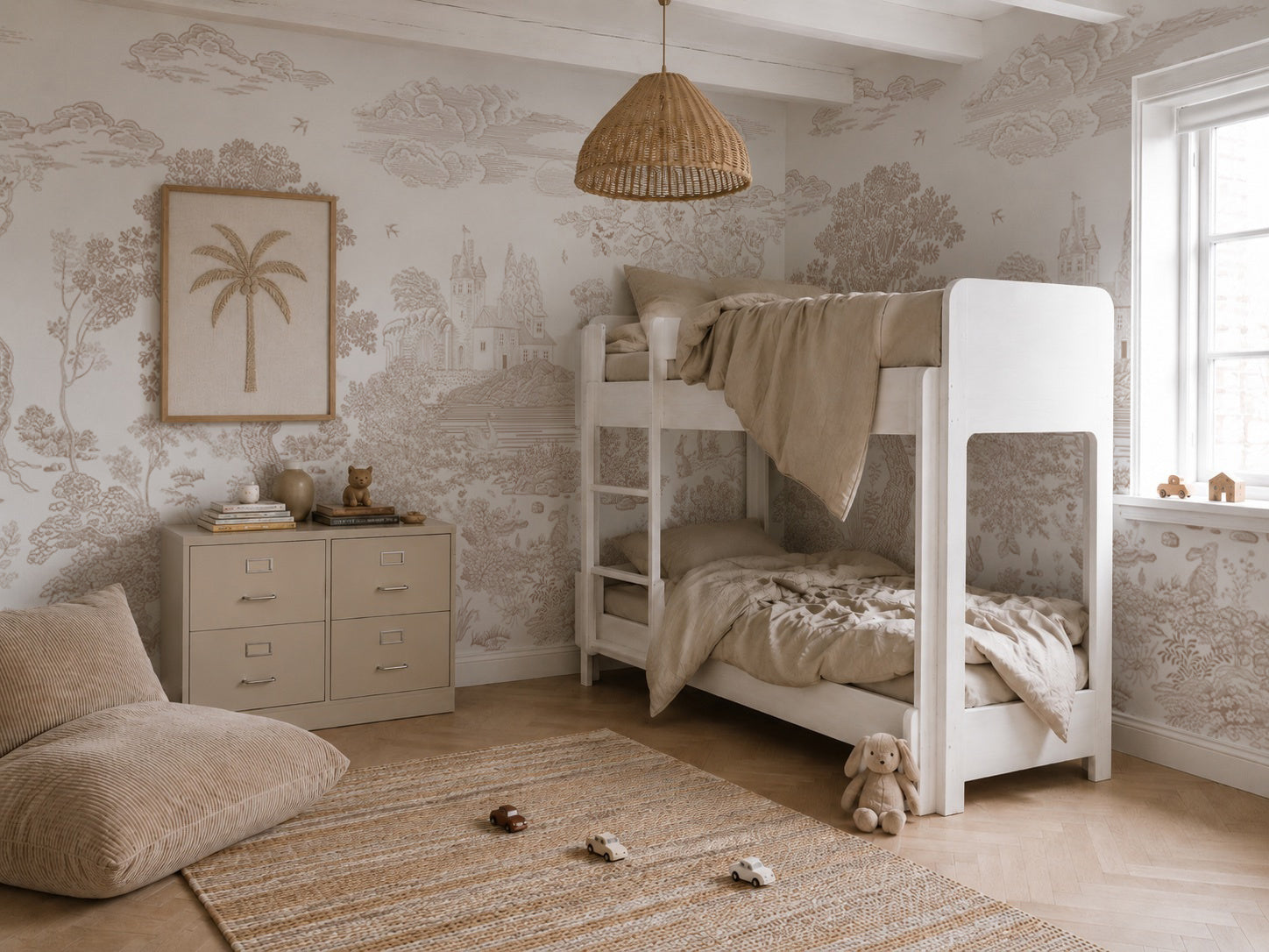 A cozy children’s bedroom featuring a white bunk bed, beige bedding, a beige dresser topped with framed palm tree art, soft toys, a woven rug, and natural light from a window. The neutral walls are given an enchanting touch by the Forest Hideaway Mural in Neutral.